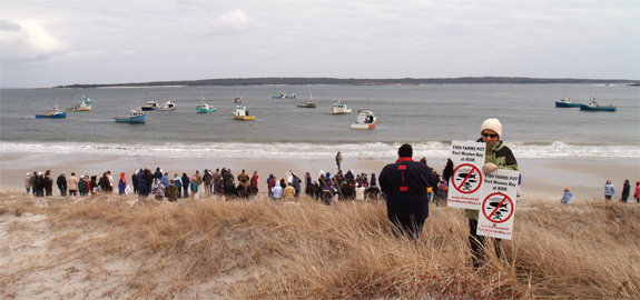 View of the rally participants on the beach with lobster boats offshore